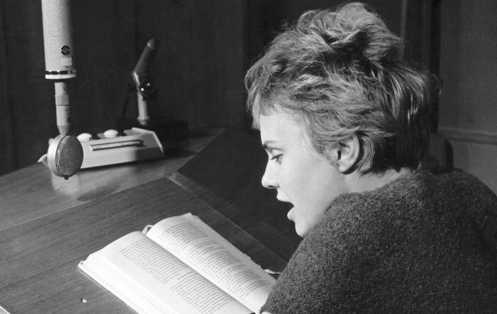 Historisches Foto: Eine Frau am Mikrofon liest ein Buch - Aktivierung öffnet Bildergalerie in größerer Ansicht