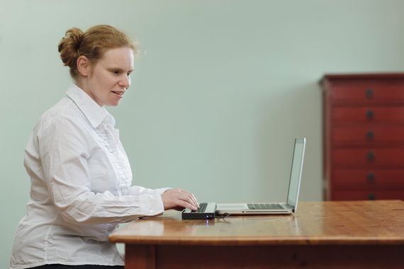 Eine junge Frau mit Braillezeile und Laptop